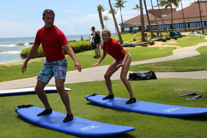 couple practicing surfing techniques on dry land