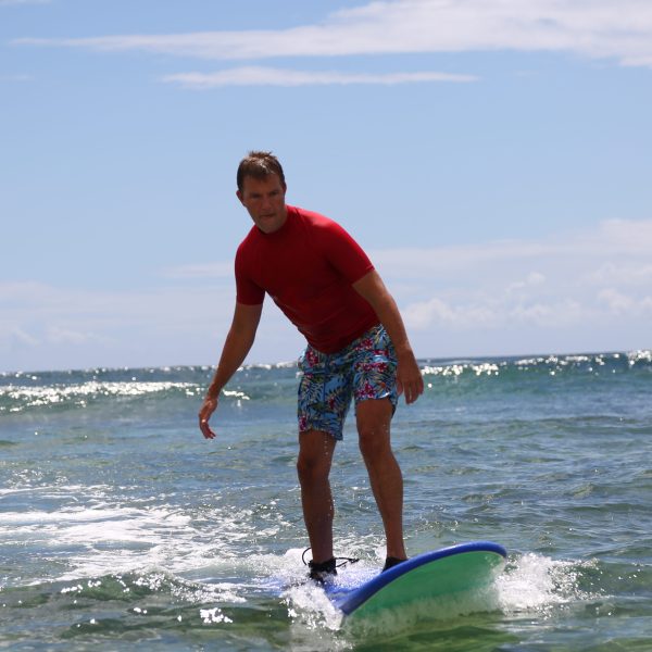 guy in red shirt surfing in kauai
