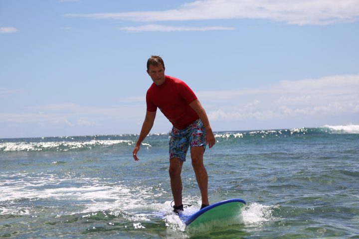 guy in red shirt surfing in kauai