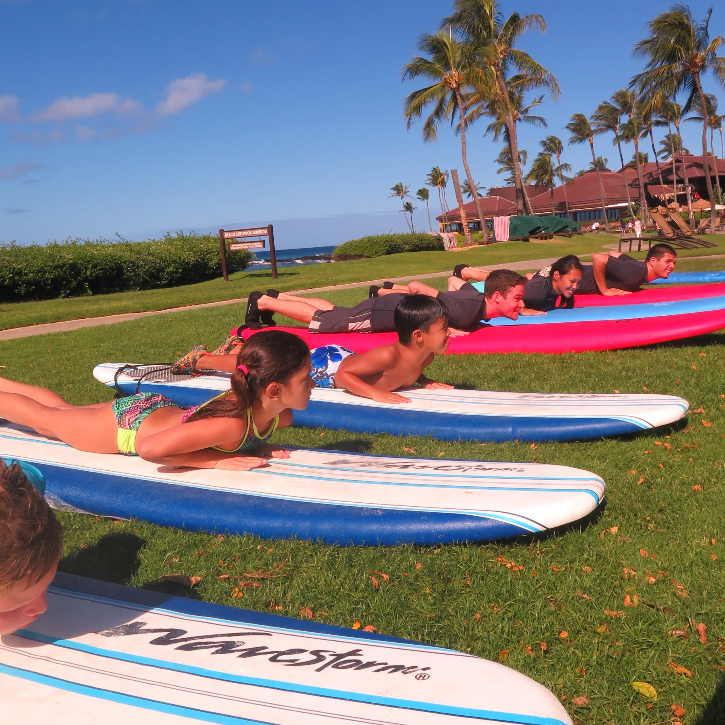 group of kids on dry land learning to surf in Kauai