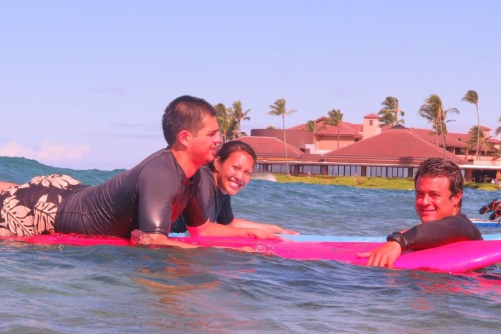 surf instructor swimming with surfers