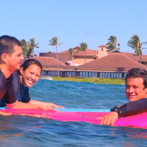 surf instructor with couple in the ocean
