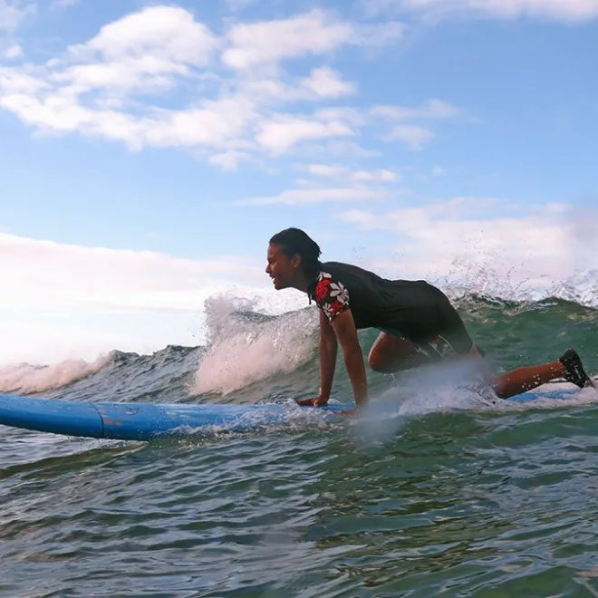 women stepping up on surfboard during wave