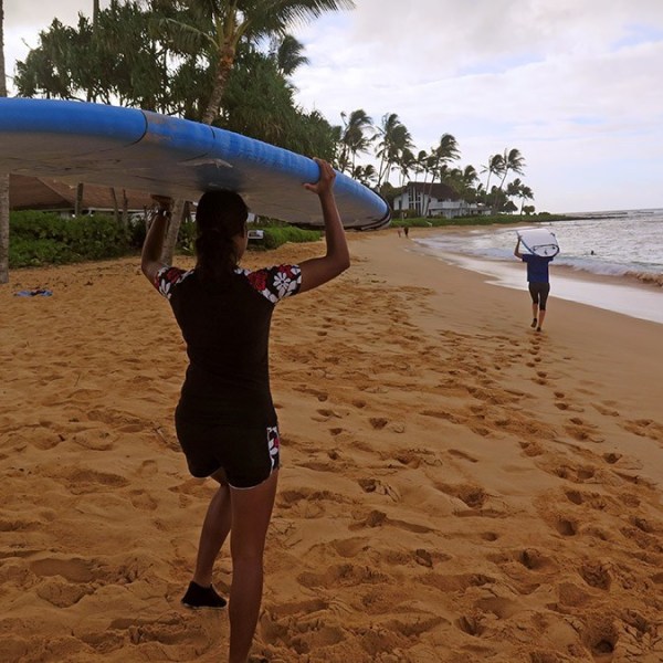 women holding surfboards on their heads