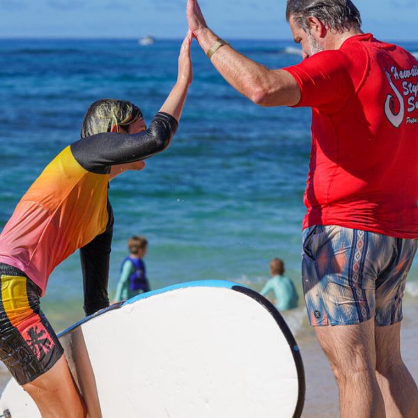 a couple high fiving after a surf lesson in kauai